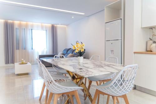 a kitchen and dining room with a table and chairs at 3-bdr apt 10-min walk laginha beach - LCGR in Mindelo