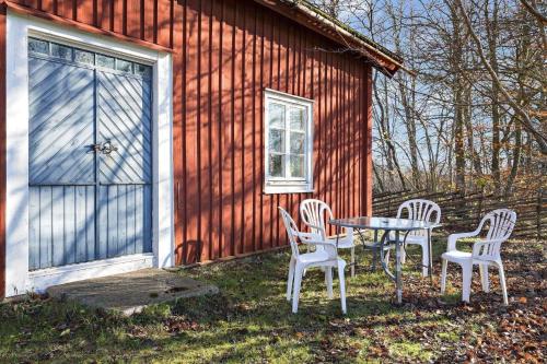 a table and chairs in front of a red barn at KRO039-Vaexjoe-Norra-Areda-6 in Östra Målajord