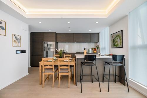 a kitchen with a wooden dining table and chairs at Urban Retreat 2BR Condo with Stunning City View in Vancouver