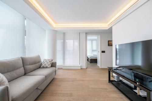 a living room with a couch and a flat screen tv at Urban Retreat 2BR Condo with Stunning City View in Vancouver