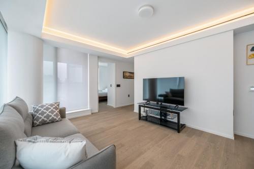 a living room with a couch and a flat screen tv at Urban Retreat 2BR Condo with Stunning City View in Vancouver