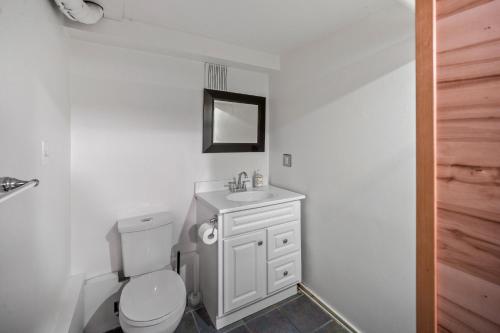 a bathroom with a white toilet and a sink at Mountain View Retreat in the heart of Banff - Massive House Sleeps 23 in Banff