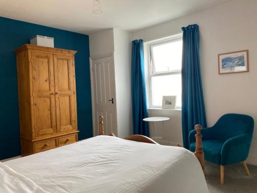 a blue bedroom with a bed and a blue chair at Riverview Apartment with Private Parking in Whitby