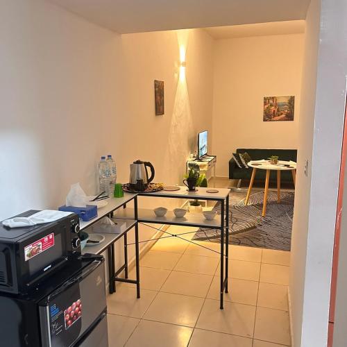 a living room with a table and a tv at GREEN SUITE ,Private Toilet ,Horizon Towers,AJMAN in Ajman