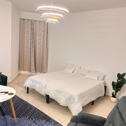 a white bedroom with a bed and a couch at GREEN SUITE ,Private Toilet ,Horizon Towers,AJMAN in Ajman