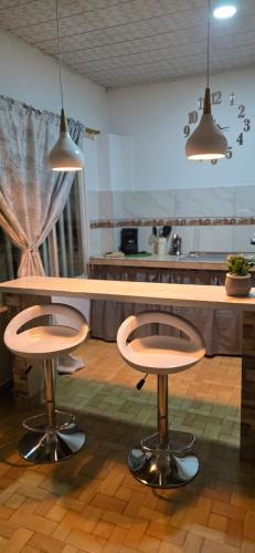 a kitchen with two bar stools and a counter at Alojamiento Sol Naciente in Puerto Triunfo
