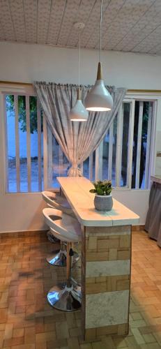 a kitchen with a table with chairs and two lights at Alojamiento Sol Naciente in Puerto Triunfo