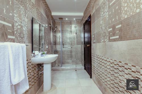 a bathroom with a shower and a sink and a toilet at Pyramids Oasis Hotel - Giza in Cairo