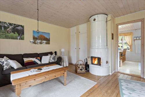 a living room with a couch and a fireplace at KAL097-Gullaskruv-Hetalaga-107 in Gullaskruv