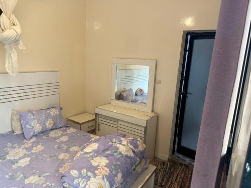 a bedroom with a bed and a mirror at Chez Zaynab in Sali Tapé
