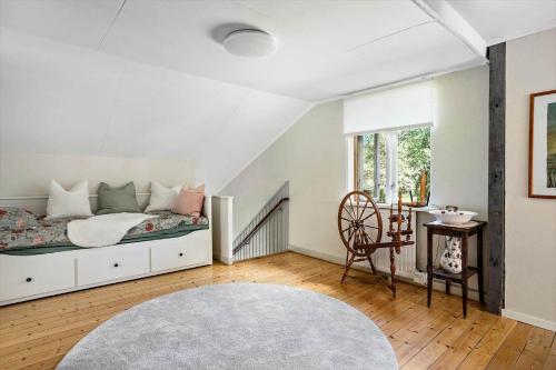 a white bedroom with a bed and a chair at KAL159-Gullaskruv-Hetalaga-111 in Gullaskruv