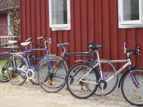 four bikes parked next to a red building at SKA601-Roeke-Roeke-Algustorp-4198 in Röke