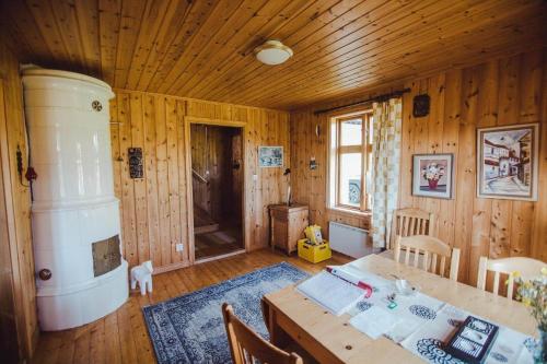 a dining room with a table and a room with wooden walls at JON707-Burseryd-Moerkebo-2 in Burseryd