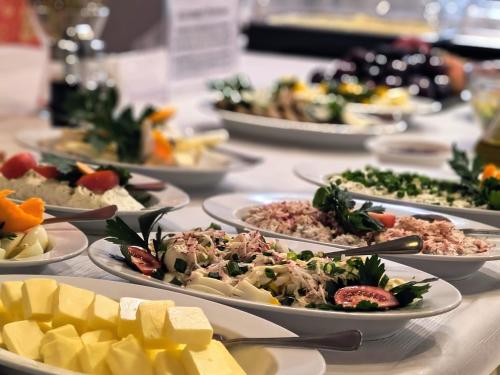 a table with many plates of food on it at Ośrodek Wypoczynkowy Olimp in Szklarska Poręba