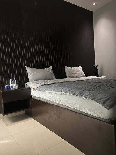 a bed with a black headboard and white pillows at غرفة وصالة بالدرعية in Riyadh