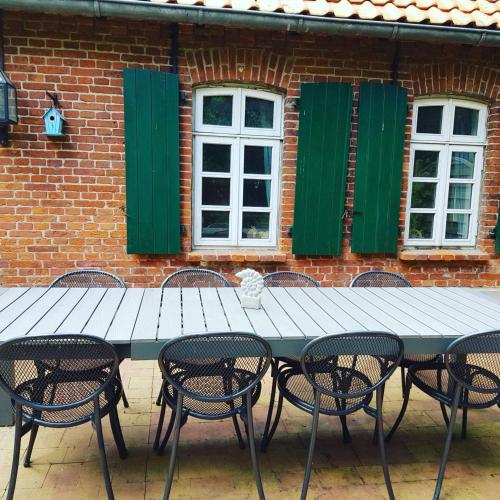 a table and chairs in front of a brick building at Dat Mullworp Huus in Hagermarsch