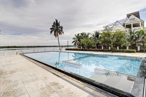 a large swimming pool in front of a house at OAK Edassery's Sealine Villa Stay in Cochin