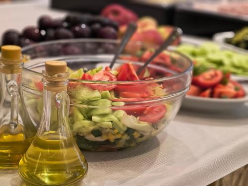 a salad in a bowl and two bottles of oil at Ośrodek Wypoczynkowy Olimp in Szklarska Poręba