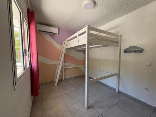 a bunk bed in a room with a ladder at Villa Massy in Rivière-Salée