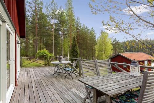 a wooden deck with a table and chairs on a house at OGO368-Boxholm-Tingkullanaes-6 in Blåvik