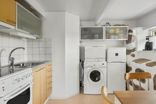 a kitchen with a refrigerator and a washer and dryer at SKA435-Bastad-Vilhelmsfaeltsvaegen-91 in Lillaryd