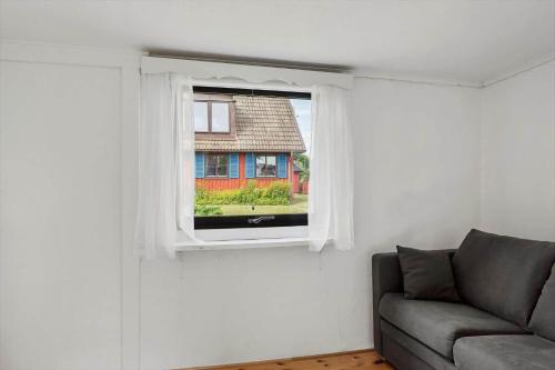 a living room with a couch and a window at SKA435-Bastad-Vilhelmsfaeltsvaegen-91 in Lillaryd