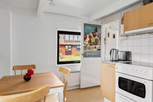 a kitchen with a table and a stove and a microwave at SKA435-Bastad-Vilhelmsfaeltsvaegen-91 in Lillaryd