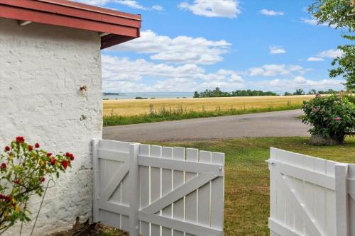 a white fence in front of a house with a field at SKA435-Bastad-Vilhelmsfaeltsvaegen-91 in Lillaryd