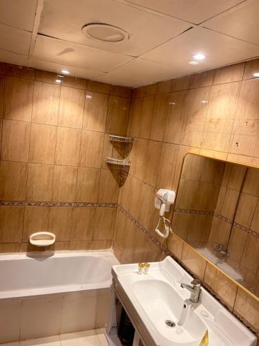 a bathroom with a sink and a bath tub at PHANTOM ,Buisness Master Suite Private Toilet , Horizon,AJMAN in Ajman 