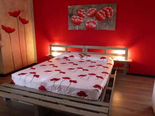 a bedroom with a bed with red walls and red flowers at La Cà ët Mec in Robilante