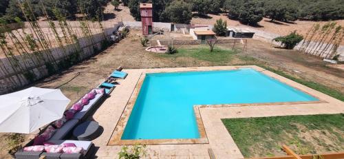 an overhead view of a swimming pool with chairs and an umbrella at Nature in Ifrane