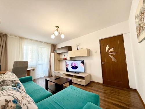 a living room with a blue couch and a television at Berzei Astra - Rise Apartments in Braşov