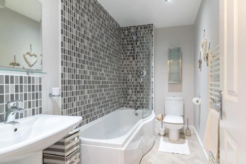 une salle de bain avec une baignoire, un lavabo et des toilettes dans l'établissement Cuthbert Cottage, à Beadnell