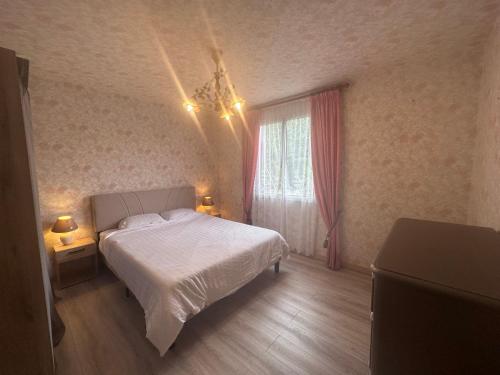 Un dormitorio con una cama blanca y una ventana. en Clos des hortensias, en Fatouville-Grestain