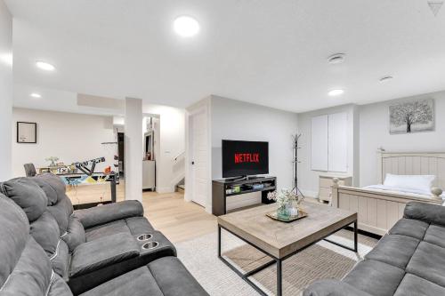 a living room with a couch and a tv at New Builtspacious Suite Bsmtgamesnetflix in Edmonton