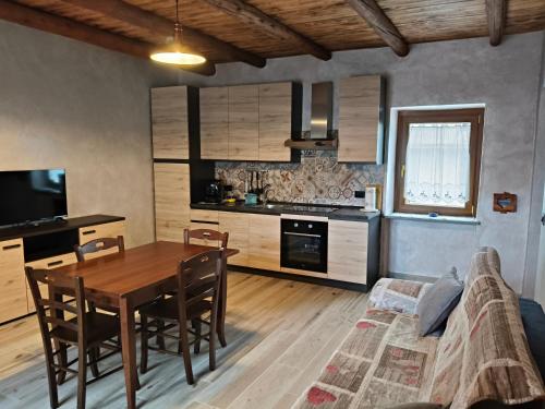 Una cocina con una mesa de madera y un comedor. en casa vacanza la Slitta, en Roure Turin