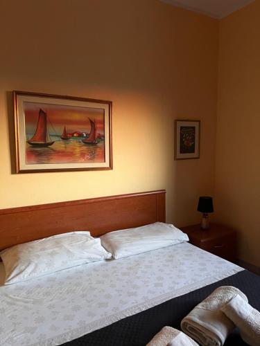 a bedroom with a bed and a painting on the wall at Affittacamere Cappuccini in Sassari