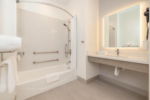 a bathroom with a shower and a tub and a sink at Travelodge by Wyndham LAX in El Segundo