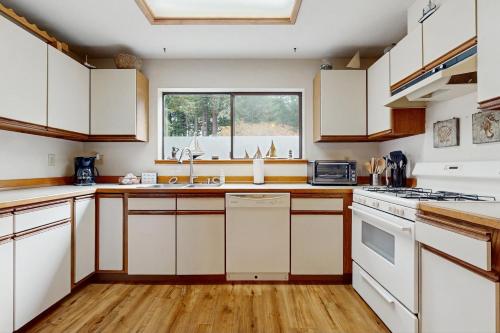 a kitchen with white cabinets and a window at Arcata Townhouse in Arcata