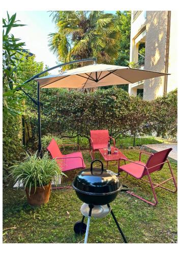 a bbq with chairs and a grill in a yard at Garden Home "Milan-Rho fair" in Solaro