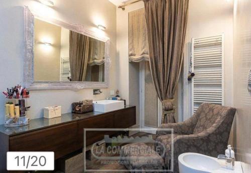 bagno con lavandino, sedia e specchio di The View of Roma a Roma