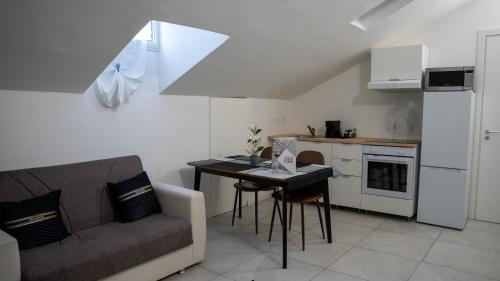 a living room with a couch and a table and a kitchen at Conte Durini Apartments & Rooms in Arcore