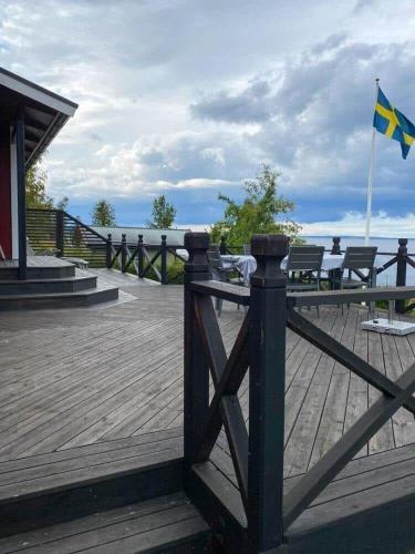 a wooden boardwalk with benches and a blue and yellow flag at VGO715-Hova-Hulan-Strandvaegen-9 in Vallsjöbol
