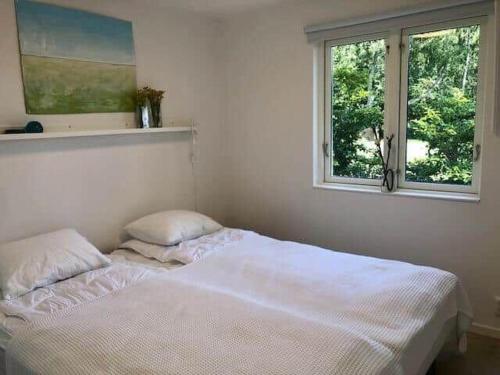 a white bed in a bedroom with a window at SKA782-Nybrostrand-Bussmevaegen-40 in Nybro