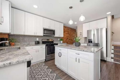a large white kitchen with white cabinets and appliances at Sophisticated Boho Condo Walkable Columbus in Columbus