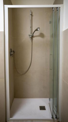 a shower with a glass door in a bathroom at Conte Durini Apartments & Rooms in Arcore