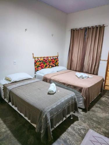 a room with two beds and a window at Hotel Urumajó in Augusto Correa