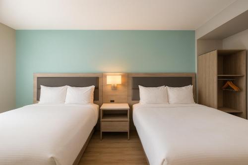 two beds sitting next to each other in a room at Travelodge by Wyndham LAX in El Segundo