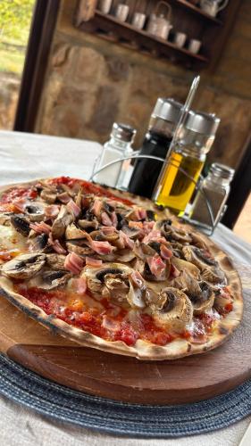 a pizza sitting on top of a wooden plate on a table at Hotel, Glampings y Cabaña Magic Bungalow in Villa de Leyva