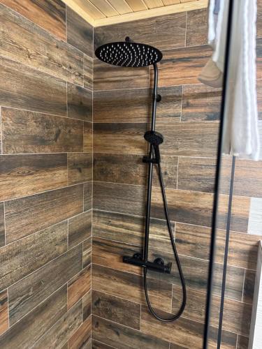 a shower with a black shower head in a bathroom at Cabana Forest LakeView Potoci in Potoci